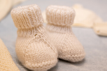 Knitted children's shoes for a boy on a light background, close-up, children's shoes. Postcard.