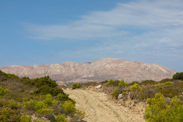 Sandy country road, 4x4 off-road trail to the peak of Attavyros mountain. Highest mountain on Rhodes island, Greece.trail. Dodecanese Greece. - obrazy, fototapety, plakaty