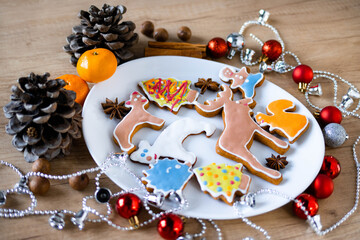 Children's hands take Christmas ginger cookies on the plate with Christmas spices and decorations....