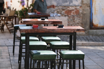 Fototapeta na wymiar Stylish slab tables and chairs in an empty street cafe