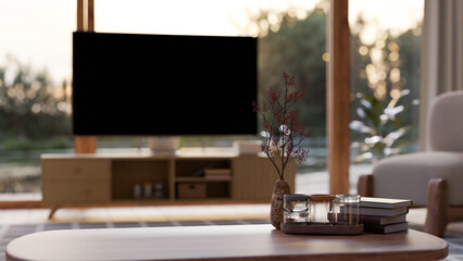 Copy space on wood coffee table over blurred living room with television in the background.