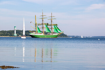 Segelschiffe und Leuchtturm bei ruhiger See