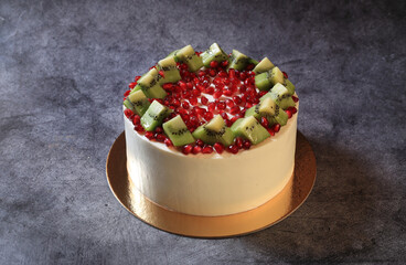 Cake with pomegranate and kiwi slices close-up