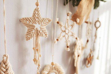 Christmas macrame decor. Christmas toy from natural materials - cotton thread, wood beads and stick. Eco decorations, ornaments, hand made decor. Winter and New Year holidays. Closeup