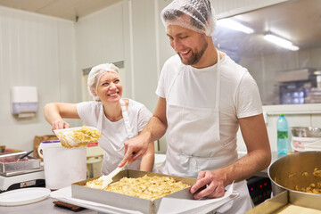 Bäcker Team beim Backen von Apfelkuchen in Teamwork