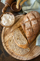 Bread from whole wheat grains, wheat bran, seeds, bio-ingredients over rustic table background. Homemade baking,  healthy lifestyle.
