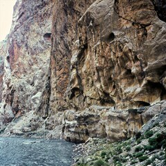Eine Person auf einem gefährlichen Fußweg mit riesigen felsigen Überhängen im Soch Canyon in Kirgistan