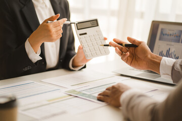 Group of business people meeting together Pointing to the graph assess business profits.