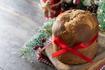 Traditional Christmas panettone on wooden table. Copy space