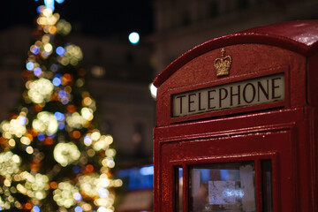 Red Telephone Booth Against Christmas Tree In Illuminated City