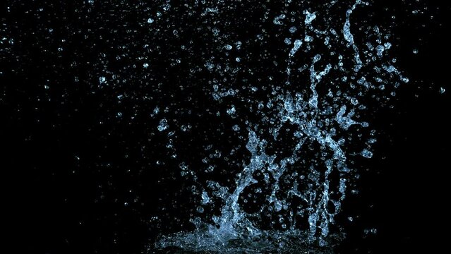 Super slow motion of splashing water crown shape on black background. Filmed on high speed cinema camera, 1000fps. Speed ramp effect.