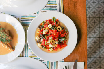cheese salad with olives in a white plate

