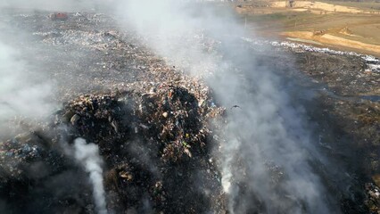Aerial view of burning trash piles in landfill - Powered by Adobe