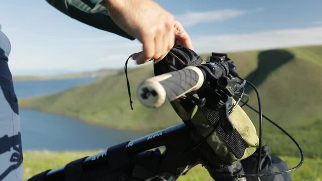 Man pack his bag at mountain bike at near outdoors
