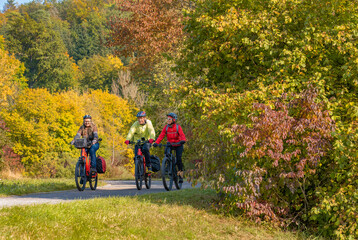 three happy senior adults, riding their mountain bikes in the autumnal atmosphere of the fall forests around city of Stuttgart, Baden Wuerttemberg, Germany
