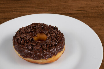 Tasty sweet donuts topped with chocolate and hazelnut cream served on a white plate. Close-up photography with centered elements.