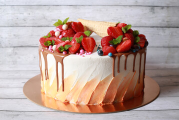 Beautiful delicious dessert cake with strawberries, mint and waffle doused with chocolate