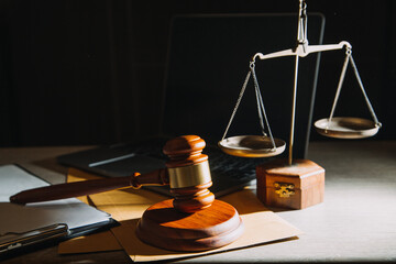 Business and lawyers discussing contract papers with brass scale on desk in office. Law, legal services, advice, justice and law concept picture with film grain effect