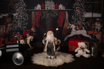 Santa Clause in the Christmas backdrop with lights, fireplace and toys