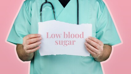Low blood sugar (Hypoglycaemia). Doctor with stethoscope in turquoise coat holds note with medical...