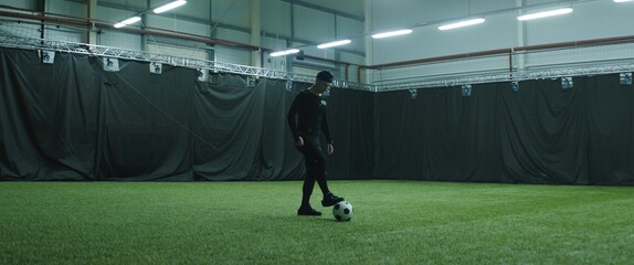 Soccer football player wearing motion capture suit performing kicks and tackles as game character....