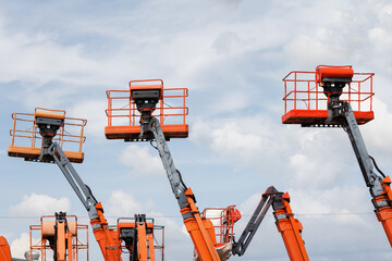 Mobile construction crane for rent and sale. Aerial work platforms of a cherry pickers with sky...
