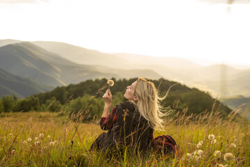 Beautiful woman sitting on mountain top and contemplating landscape.