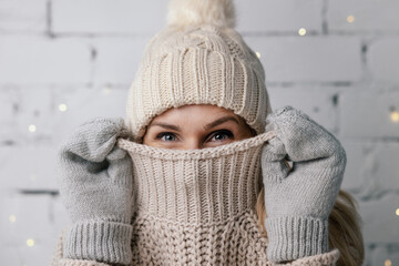 Fototapeta woman hiding face in wool winter sweater. cold weather clothes obraz
