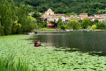 Fishing in a lake next to a village in lago di lago Italy with lilypads