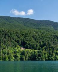 A lonely house in the forest at the foot of a mountain next to a river in Barcis, Italy