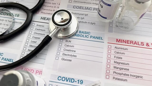 Black stethoscope over requisition form paper on work table of doctor. Workplace of specialist medical with phonendoscope, drugs vials over medical petition Report