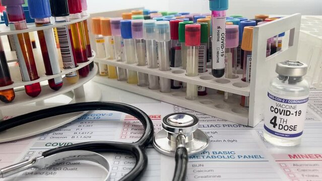 Technican holding blood sample with presence positive to covid or coronavirus over requisition form. Doctor holding tube of blood sample identified with Positive COVID-19 or Coronavirus in the laborat