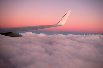 Widok z okna na skrzydło samolotu nad chmurami - obrazy, fototapety, plakaty