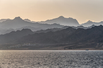 Mountains silhouettes and sea at sunset