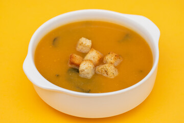 Vegetable cream soup with dry bread in white bowl