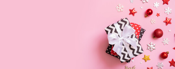 Christmas presents flat lay on a pink background. Top view xmas gifts with decorations