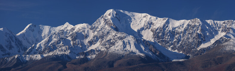 Obraz premium Snow-capped mountain peaks, contrasting morning light, large panorama