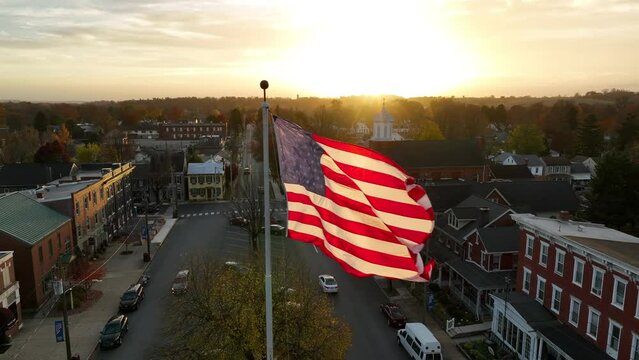 American flag at sunset. Slow motion aerial of USA flag waving in wind. Patriotic America theme.