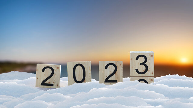 2022 change to 2023 concept wood box flipping on blur background. sign in celebration of the new year