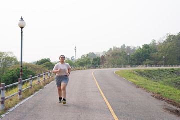 Front view, wide shot with copy space of an active fat young Asian woman with eyeglasses in...