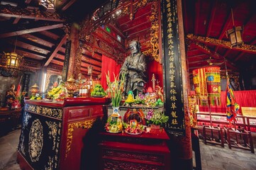 Mooie opname van een boeddhistisch tempelaltaar met een standbeeld van Confucius en versieringen in Vietnam