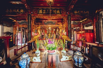 Schöne Aufnahme eines buddhistischen Tempelaltars mit einer Konfuzius-Statue und Dekorationen in Vietnam