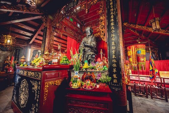 Beautiful shot of a Buddhist temple altar with a Confucius statue and decorations in Vietnam