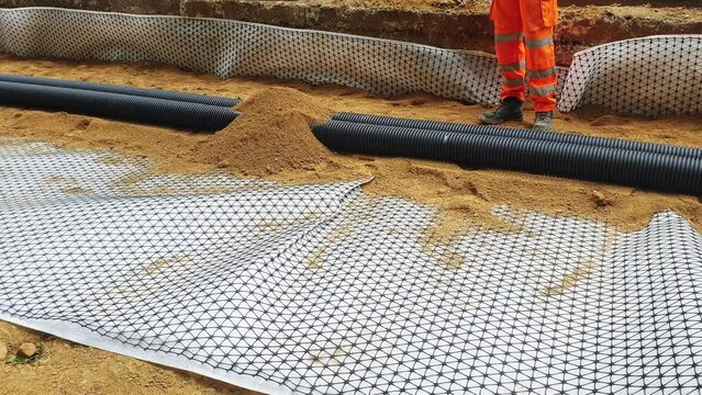 Groundworkers installing new electric ducts during roadworks	