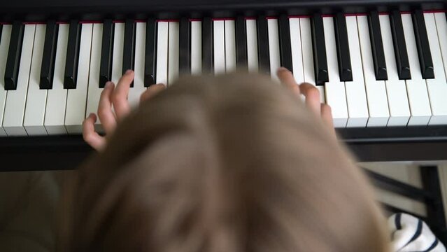 Closeup of teenager playing piano in home music studio. Girl having online class and practicing on modern electric piano