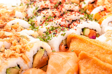 Close up of delicious japanese food with sushi roll  with salmon, tuna,  shrimp with wooden chopsticks  on white background