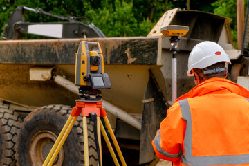 Surveyor site engineer with total positioning station on the construction site of the new road...
