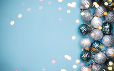 Christmas baubles on blue background. Frame border. Christmas New Year composition background blue grey silver colored. Christmas lights. Minimal concept.