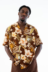 African american man holding hands in pocket looking at camera serious look wearing fashionable beautiful shirt and brown pants