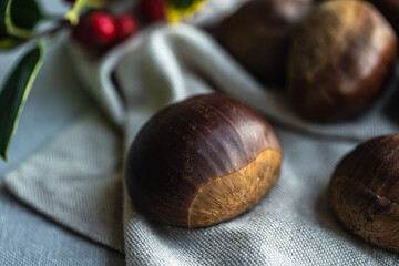 Step by step process of making roasted chestnuts. Heap of raw chestnuts on linen cloth.